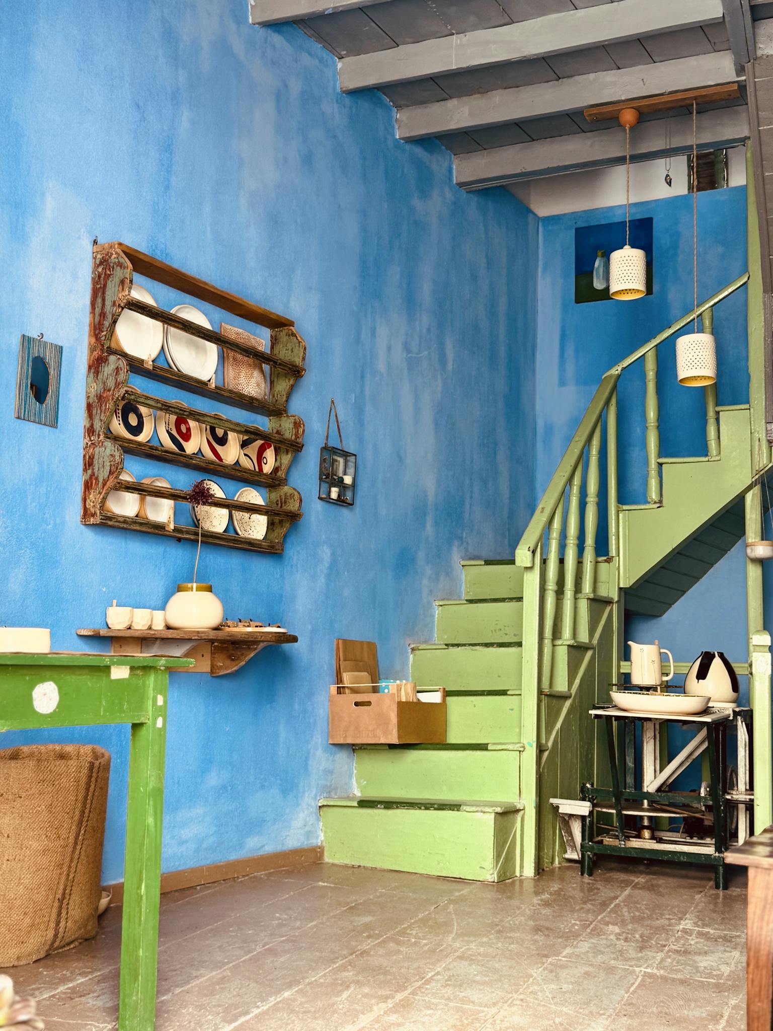 Bright and colorful interior featuring rustic decor and a green staircase.
